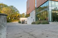 the courtyard features concrete, plants and a fire hydrant surrounded by trees and glass windows