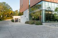 the courtyard features concrete, plants and a fire hydrant surrounded by trees and glass windows