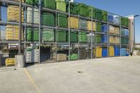 several crates filled with assorted produce sitting on top of each other in front of a metal fence