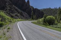 the long road runs down to some steep mountains and valleys that is covered with trees