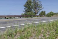 a view of an empty road leading to the mountains on a sunny day, with a lone bike sitting in the middle of the street