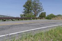 a view of an empty road leading to the mountains on a sunny day, with a lone bike sitting in the middle of the street