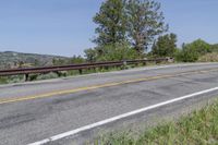 a view of an empty road leading to the mountains on a sunny day, with a lone bike sitting in the middle of the street