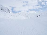 a cross country skier is traveling down a snowy slope in the mountains to ski on