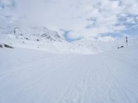 a cross country skier is traveling down a snowy slope in the mountains to ski on