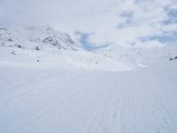 a cross country skier is traveling down a snowy slope in the mountains to ski on