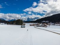 person cross country skiing on snowy terrain with mountains in the background for use as backdrop