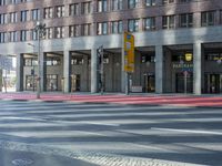 a street in front of an office building and a bicycle lane, with a bus parked next to it