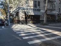 the crosswalk is waiting to cross the street, with several cars driving near by