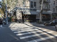 the crosswalk is waiting to cross the street, with several cars driving near by