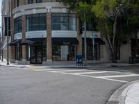 a corner with a parking meter at the intersection of the street with cars and tall buildings