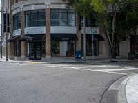 a corner with a parking meter at the intersection of the street with cars and tall buildings