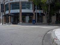 a corner with a parking meter at the intersection of the street with cars and tall buildings