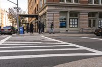 a white crosswalk next to some people walking down the street with a car and taxi