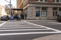 a white crosswalk next to some people walking down the street with a car and taxi