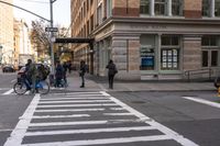a white crosswalk next to some people walking down the street with a car and taxi