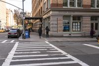 a white crosswalk next to some people walking down the street with a car and taxi
