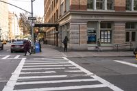 a white crosswalk next to some people walking down the street with a car and taxi