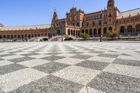 a crowd is walking around in the courtyard of an ornate building with circular patterns on stone flooring