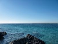 the ocean is blue and clear as seen from the shore of a beach in cuba