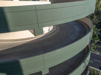 a red, blue and green skate board on the edge of a curved driveway and building