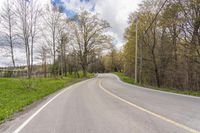 a curve highway in the woods with no cars on it and signs along the road