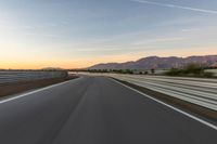 a photo of a dirt race track with sun setting in the distance of the track