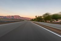 a photo of a dirt race track with sun setting in the distance of the track