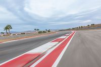 a photo of a dirt race track with sun setting in the distance of the track