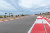 a photo of a dirt race track with sun setting in the distance of the track