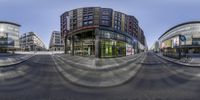 the curved building in a big city is very high and full of shops and buildings