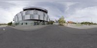 a distorted image shows the intersection of an empty parking lot and a curved building with many windows