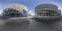 a pair of curved buildings in front of a road with a light on each side