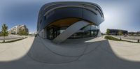 a fish eye lens image of a building with circular shapes on the roof and a curved facade