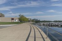 a curved building with a glass front next to another building in a city park area