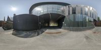 a fisheye lens view of a modern building with curved glass walls and large windows