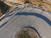 a curved road next to mountains and a sky view sign in the middle of it