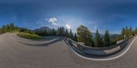 a curved road in the middle of mountains with a cloudless sky in the background