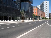 a curved road with two white lines in front of large buildings and a city sidewalk