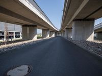 a curved road in front of several overpasses on an elevated roadway with rocks, gravel and gravel around