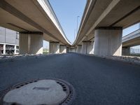 a curved road in front of several overpasses on an elevated roadway with rocks, gravel and gravel around