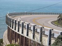 the road is curved near the beach and ocean side highway by it's sides