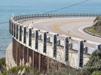 the road is curved near the beach and ocean side highway by it's sides