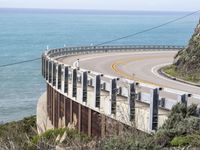 the road is curved near the beach and ocean side highway by it's sides