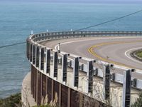 the road is curved near the beach and ocean side highway by it's sides