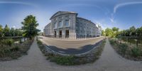 a 360 view camera captures a building with a curved road going down to it's sides