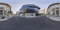 360 panning photo of a curved road and buildings with a large glass dome on it