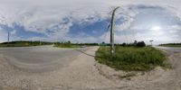 a fisheye photo of a curved road and two streets in the background with power lines