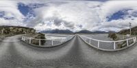 fisheye image of a curve road with mountains in the background, and a road running in opposite directions