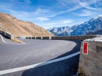 road on the side of mountain with curved curve leading to the mountains on the right